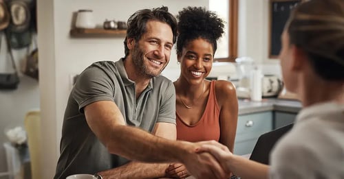 Homeowners shaking hands with an insurance agent after getting homeowner's insurance